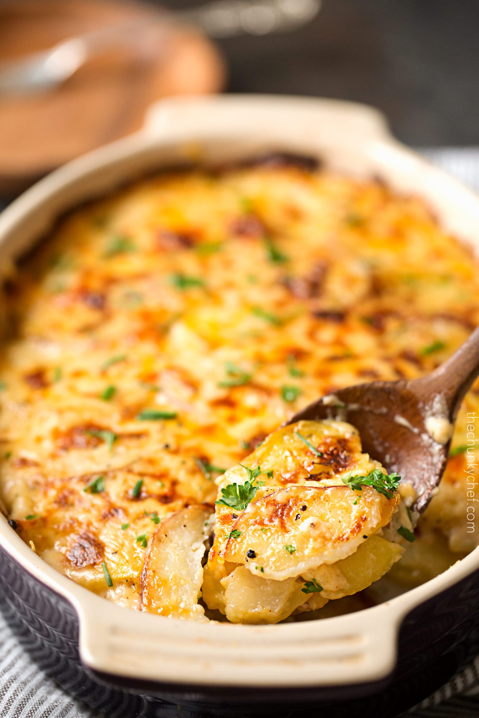 Garlic Parmesan Cheesy Scalloped Potatoes | Velvety soft and tender layers of two kinds of potatoes, smothered in a rich 3 cheese garlic sauce, then topped with extra cheese for a perfectly crispy top! It's the scalloped potato dish you've been dreaming of your entire life! | http://thechunkychef.com