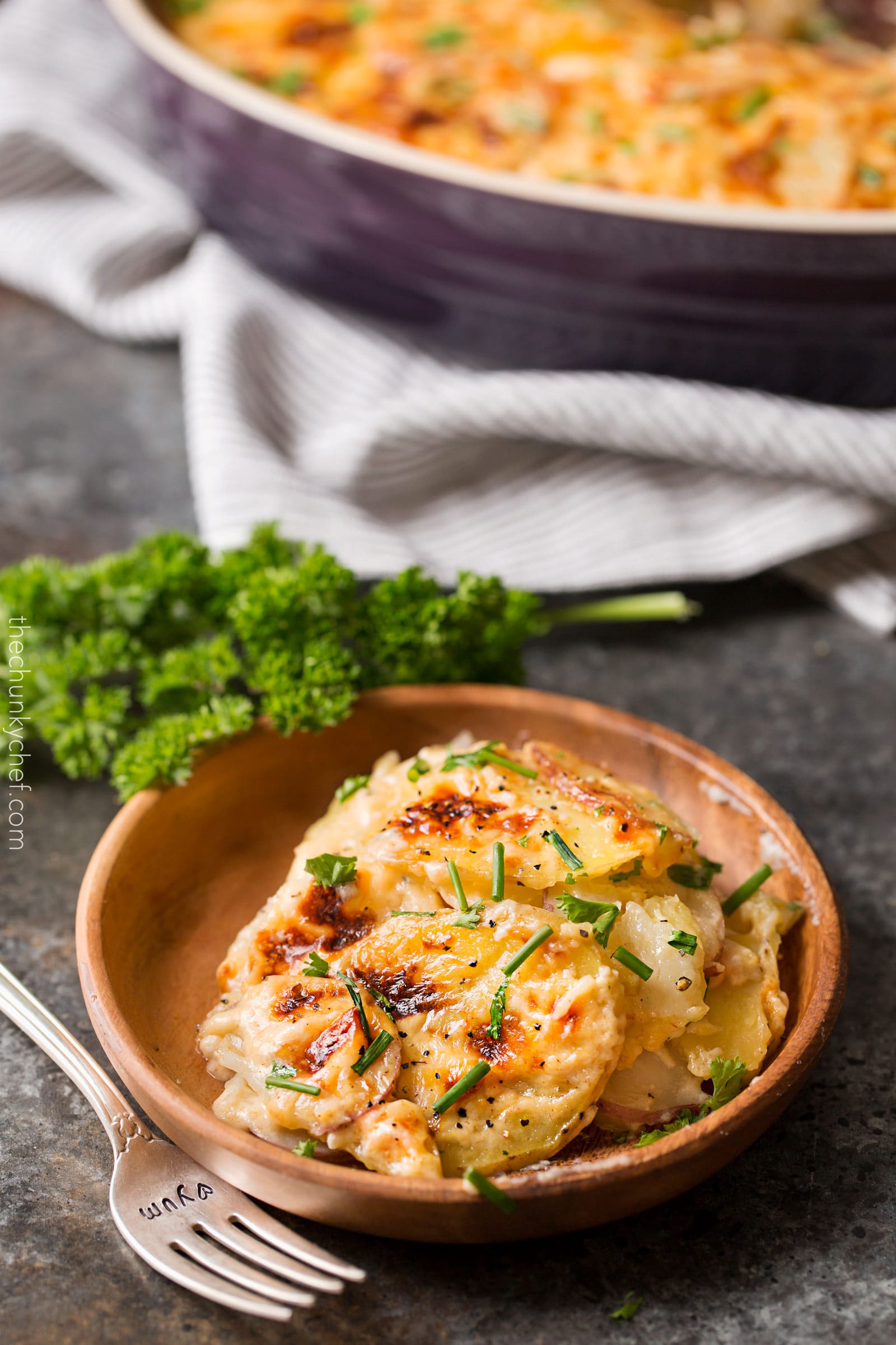 Garlic Parmesan Cheesy Scalloped Potatoes | Velvety soft and tender layers of two kinds of potatoes, smothered in a rich 3 cheese garlic sauce, then topped with extra cheese for a perfectly crispy top! It's the scalloped potato dish you've been dreaming of your entire life! | http://thechunkychef.com