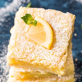 Lemon bars with lemon slice on top with powdered sugar