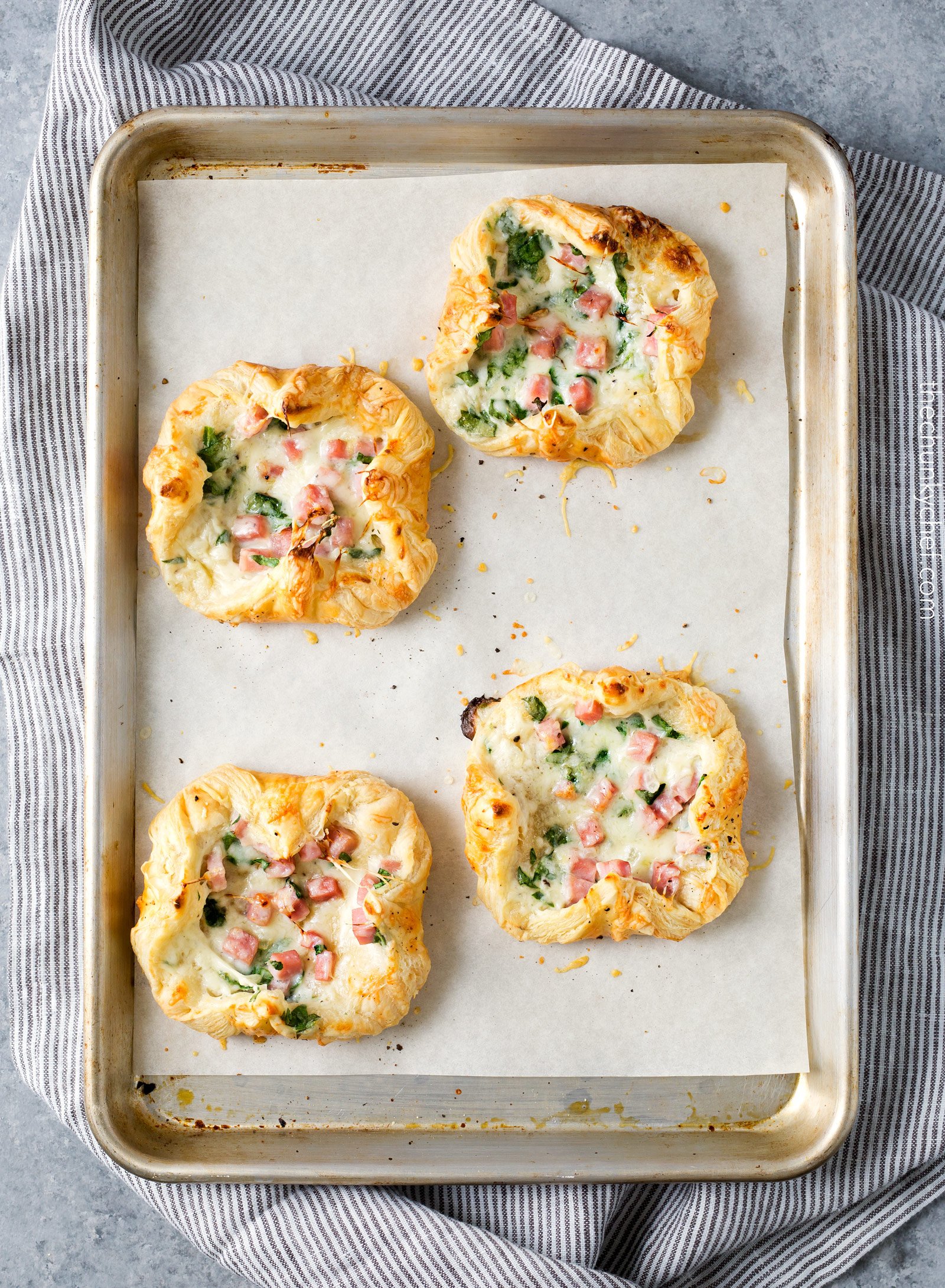 Ham and Cheese Spinach Puffs | Ready in just over 30 minutes, these spinach puffs are made with flaky puff pastry, wrapped around a creamy mixture of ham, gruyere cheese and fresh spinach. Perfect for using leftover ham! | http://thechunkychef.com