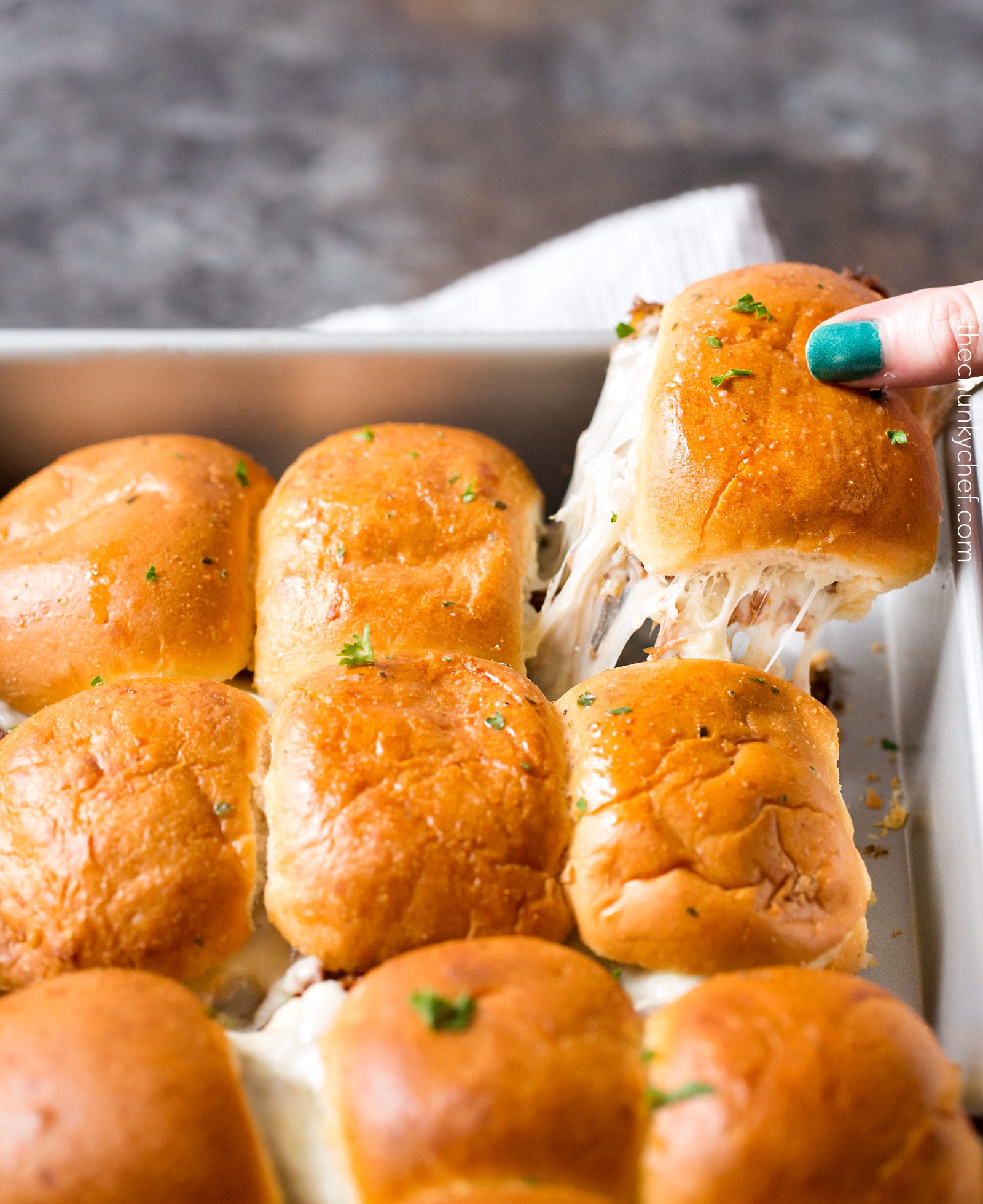 Baked Italian Beef Sliders | Slider buns are piled high with shredded Italian beef and gooey provolone cheese, brushed with melted garlic butter and baked until gooey and mouthwatering! | http://thechunkychef.com