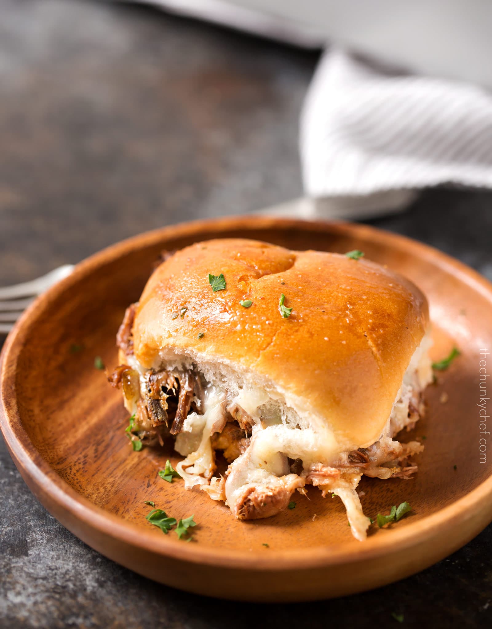 Baked Italian Beef Sliders | Slider buns are piled high with shredded Italian beef and gooey provolone cheese, brushed with melted garlic butter and baked until gooey and mouthwatering! | http://thechunkychef.com