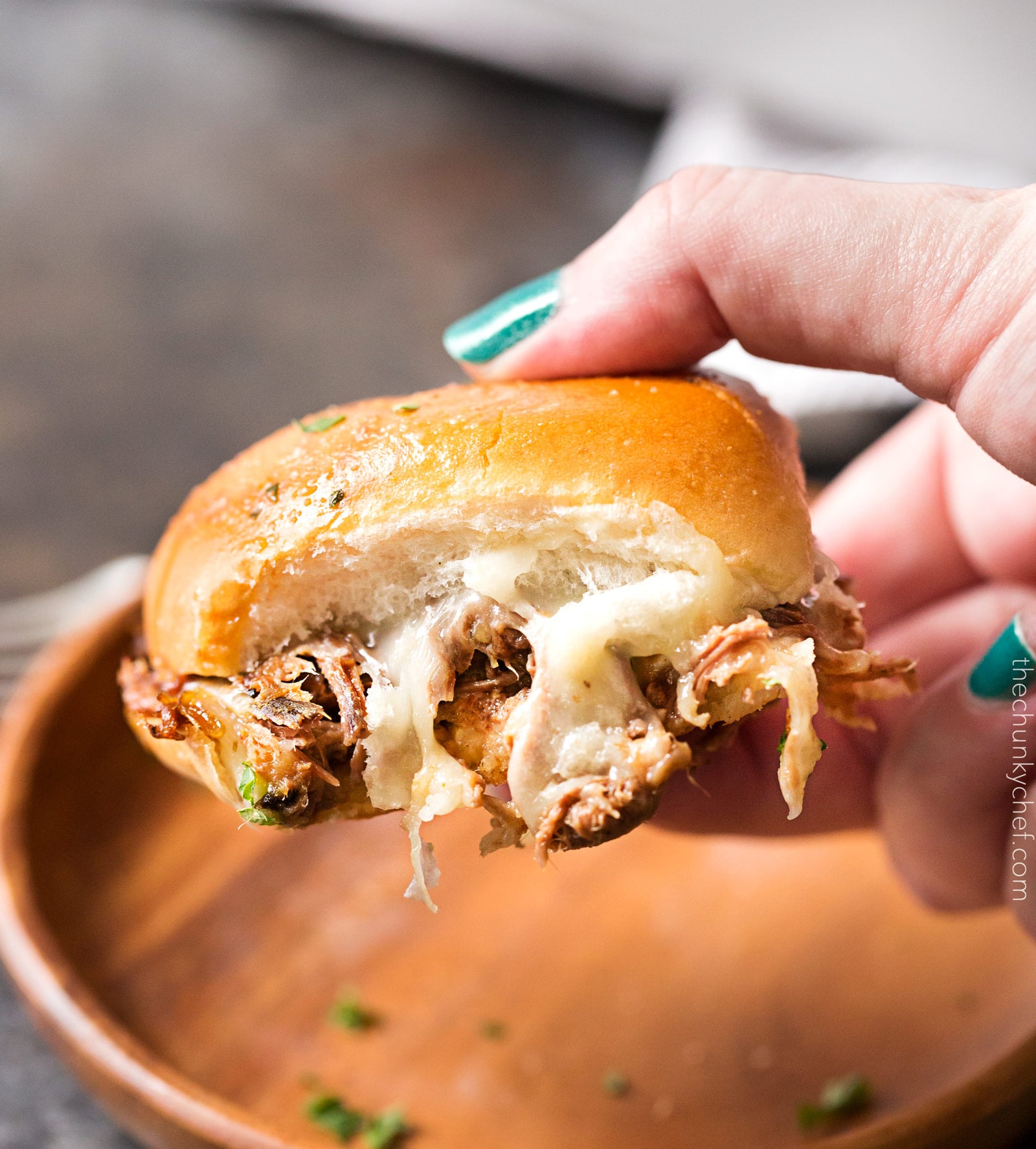 Baked Italian Beef Sliders | Slider buns are piled high with shredded Italian beef and gooey provolone cheese, brushed with melted garlic butter and baked until gooey and mouthwatering! | http://thechunkychef.com