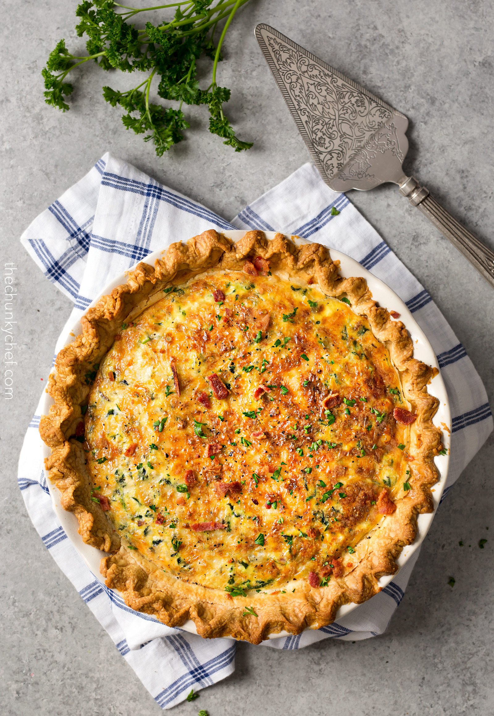 Basic Cheesy Spinach Quiche with Bacon | This easy quiche is loaded with spinach, ham, bacon, caramelized onions, mushrooms and Gruyere! No complicated dinner here, it uses frozen pie crust! | http://thechunkychef.com