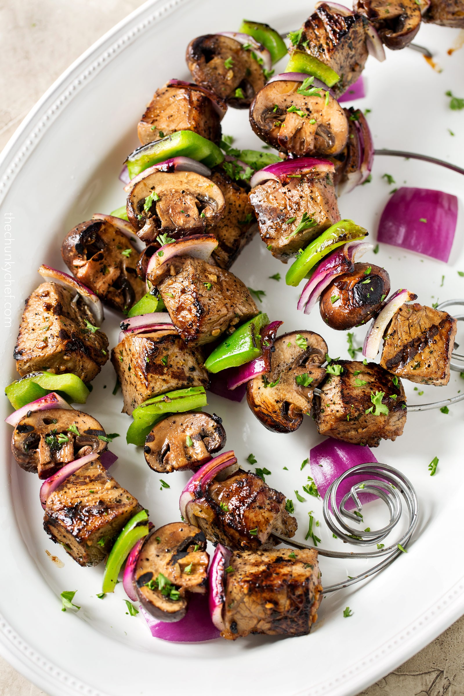 Easy Grilled Steakhouse Kebabs | Bite-sized steak pieces and mushrooms are marinated in an incredibly easy marinade, then skewered with onions and peppers, and grilled to juicy steakhouse perfection! You need these at your next BBQ! | http://thechunkychef.com