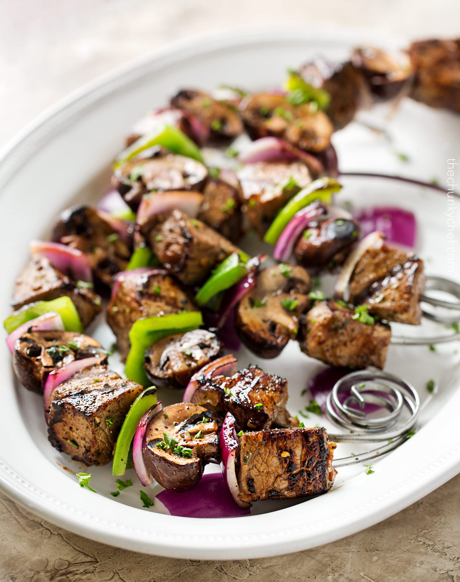 Easy Grilled Steakhouse Kebabs | Bite-sized steak pieces and mushrooms are marinated in an incredibly easy marinade, then skewered with onions and peppers, and grilled to juicy steakhouse perfection! You need these at your next BBQ! | http://thechunkychef.com