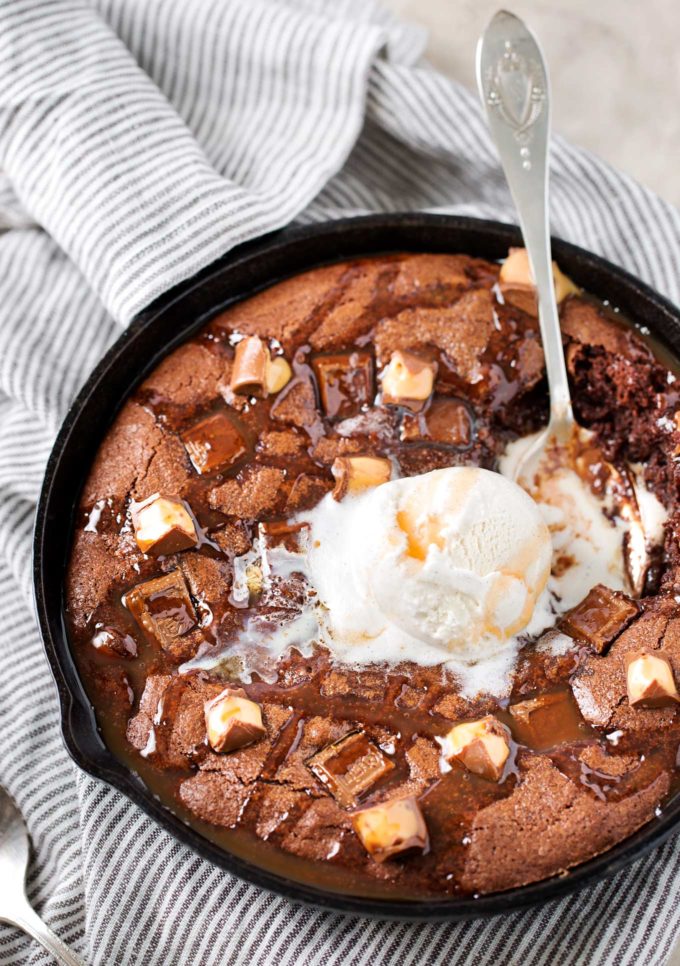 This one bowl brownie recipe is baked in a skillet, which means you can dig right into the gooey, warm brownie right away!  Stuffed with caramel and chocolate, this is one loaded brownie! #brownie #brownies #brownierecipe #dessert #dessertrecipe #skillet #easyrecipe #caramel #chocolate