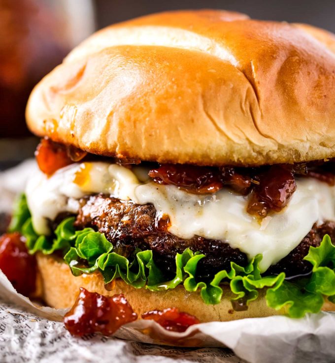 cheeseburger on newspaper with lettuce and bacon jam