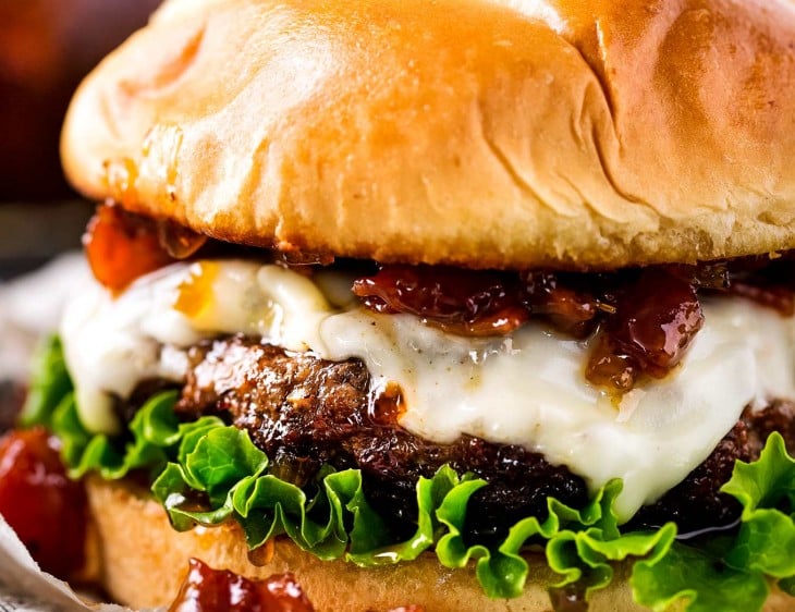 cheeseburger on newspaper with lettuce and bacon jam