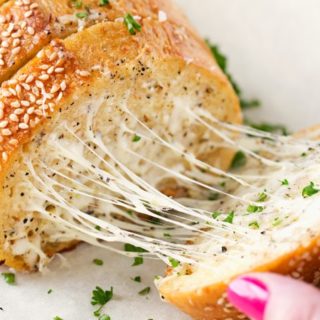 Homemade Garlic Bread | Who knew homemade garlic bread could be so easy! Start off with your favorite bakery bread, add a mouthwatering garlic parmesan and herb spread, extra cheese if you want, and bake until warm, gooey, buttery and toasty! | http://thechunkychef.com
