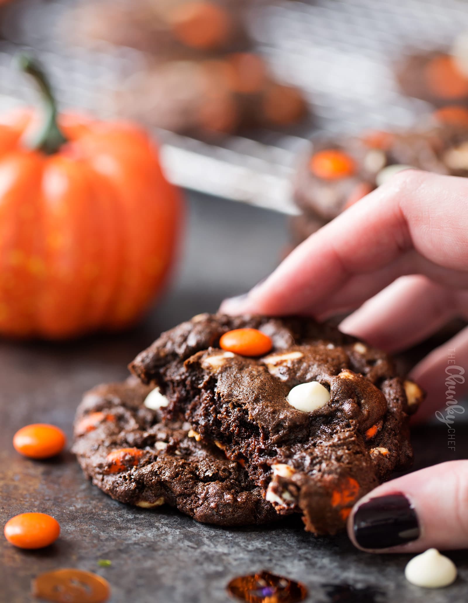 Peanut Butter Candy Double Chocolate Cookies | Fudgy and chewy double chocolate cookies, studded with white chocolate chips and Reese's pieces candies, which give them a fun Halloween look! | https://www.thechunkychef.com | #cookies #holiday #chocolate #baking