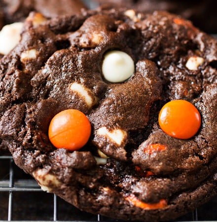 Peanut Butter Candy Double Chocolate Cookies | Fudgy and chewy double chocolate cookies, studded with white chocolate chips and Reese's pieces candies, which give them a fun Halloween look! | https://www.thechunkychef.com | #cookies #holiday #chocolate #baking