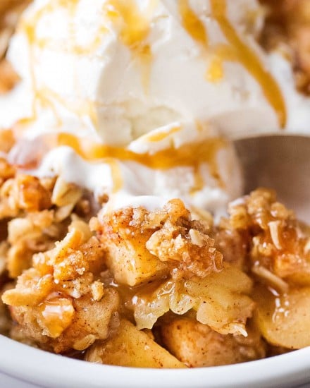 This Old Fashioned Apple Crisp takes chopped apples, cinnamon, brown sugar, and the best crispy oat topping, and is baked into the ultimate Fall dessert!  Top with a scoop of ice cream and salted caramel for the perfect treat! #applecrisp #oat #falldessert #appledessert #fromscratch