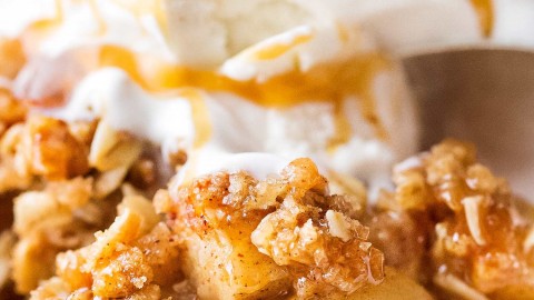 This Old Fashioned Apple Crisp takes chopped apples, cinnamon, brown sugar, and the best crispy oat topping, and is baked into the ultimate Fall dessert!  Top with a scoop of ice cream and salted caramel for the perfect treat! #applecrisp #oat #falldessert #appledessert #fromscratch