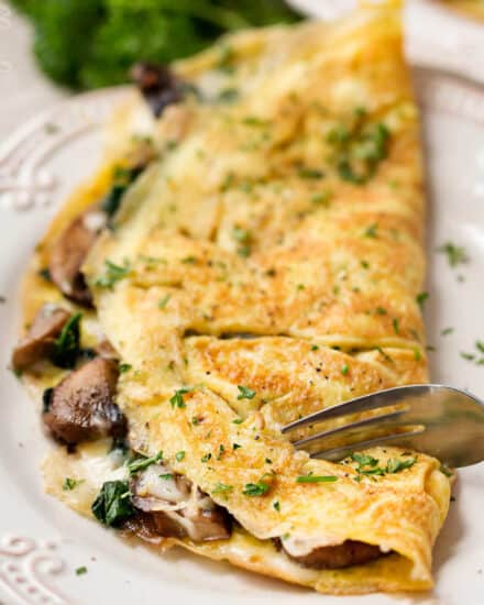 Cheesy Mushroom and Spinach Omelet | This easy browned omelet is filled with sautéed mushrooms, onions, wilted spinach, and plenty of gooey Gruyere cheese! | https://thechunkychef.com | #omelet #breakfast #brunch #omelette #eggrecipe #breakfastrecipe