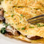 Cheesy Mushroom and Spinach Omelet | This easy browned omelet is filled with sautéed mushrooms, onions, wilted spinach, and plenty of gooey Gruyere cheese! | https://thechunkychef.com | #omelet #breakfast #brunch #omelette #eggrecipe #breakfastrecipe