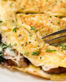 Cheesy Mushroom and Spinach Omelet | This easy browned omelet is filled with sautéed mushrooms, onions, wilted spinach, and plenty of gooey Gruyere cheese! | https://thechunkychef.com | #omelet #breakfast #brunch #omelette #eggrecipe #breakfastrecipe