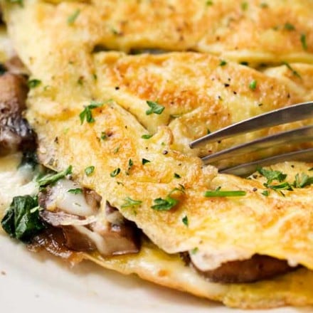 Cheesy Mushroom and Spinach Omelet | This easy browned omelet is filled with sautéed mushrooms, onions, wilted spinach, and plenty of gooey Gruyere cheese! | https://thechunkychef.com | #omelet #breakfast #brunch #omelette #eggrecipe #breakfastrecipe