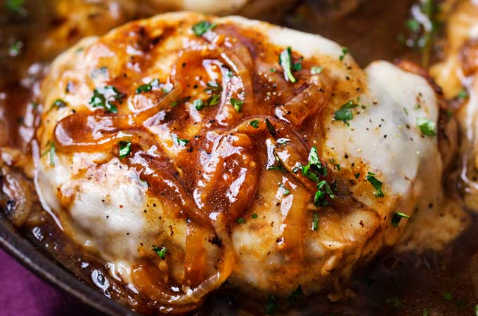 One Pan French Onion Smothered Pork Chops | Juicy pan-seared pork chops, smothered in caramelized onion sauce and 2 kinds of gooey cheese. It's easy to break out of a dinner rut with this fun weeknight meal! | The Chunky Chef | #porkchops #porkchopsrecipe #onepan #onepot #frenchonion #weeknightmeal