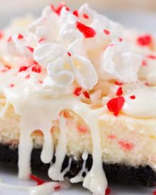 Peppermint White Chocolate Cheesecake Bars | An Oreo cookie crust, velvety smooth white chocolate peppermint cheesecake filling, candy cane pieces, and an extra drizzle of creamy white chocolate. Holiday baking at it's finest! | The Chunky Chef | #cheesecakerecipes #cheesecakebars #peppermint #whitechocolate #holidaybaking #Christmasdesserts