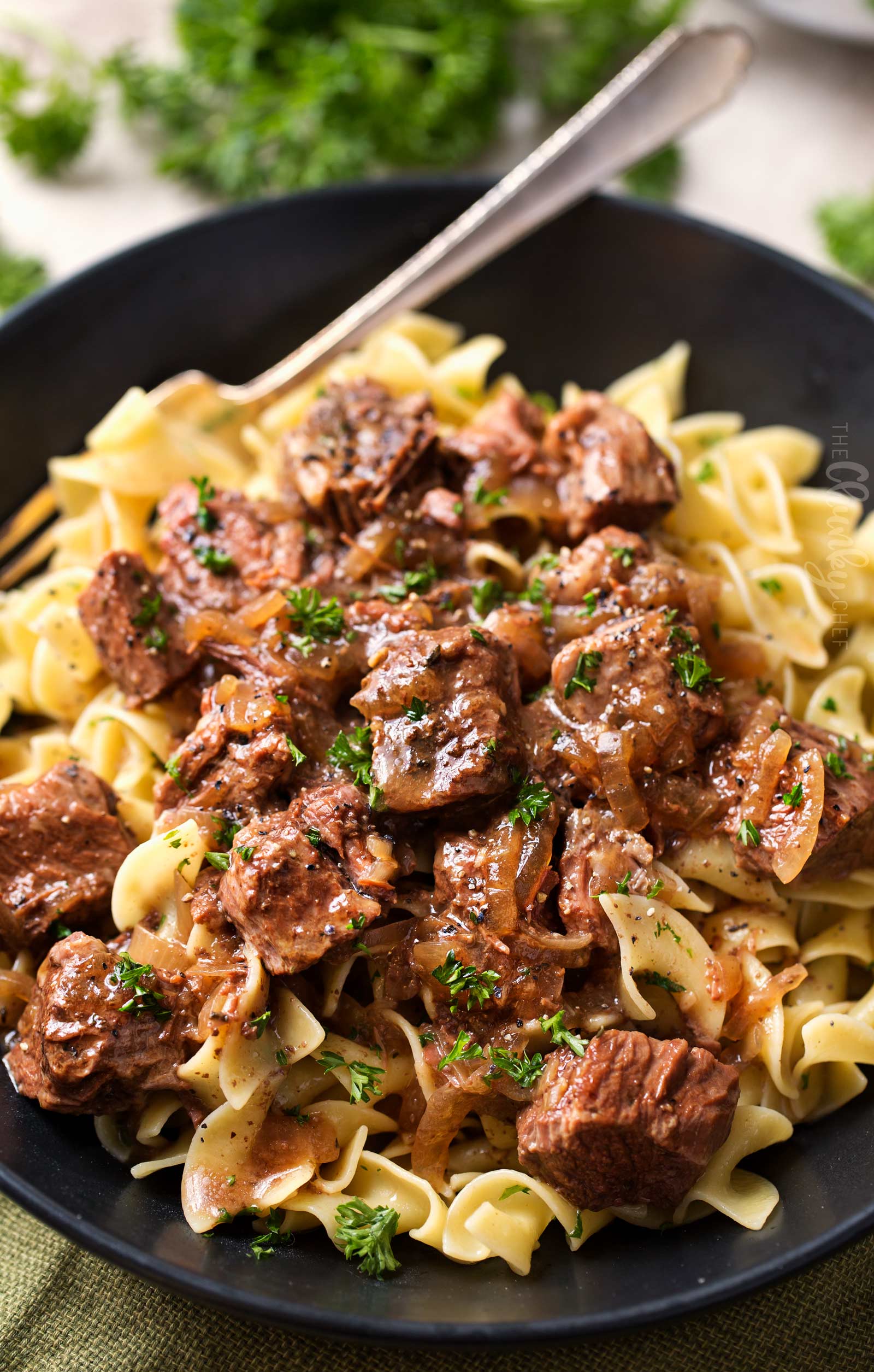 Drunken Slow Cooker Beef Stew (Beef Carbonnade) | Belgium comfort food, made easy in the slow cooker!  Beef stew made with plenty of sweet onions, herbs and beer... perfect over egg noodles, mashed potatoes, or with a crusty piece of bread! | The Chunky Chef | #beefcarbonnade #beefstew #comfortfoodrecipe #slowcookerrecipes #crockpotrecipes #crockpotbeefrecipes