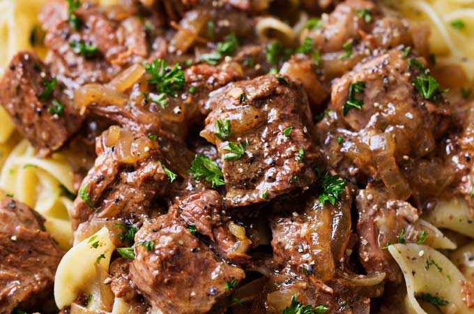 Drunken Slow Cooker Beef Stew (Beef Carbonnade) | Belgium comfort food, made easy in the slow cooker!  Beef stew made with plenty of sweet onions, herbs and beer... perfect over egg noodles, mashed potatoes, or with a crusty piece of bread! | The Chunky Chef | #beefcarbonnade #beefstew #comfortfoodrecipe #slowcookerrecipes #crockpotrecipes #crockpotbeefrecipes