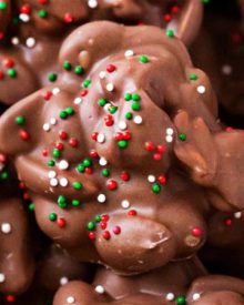 Easy Christmas Crockpot Candy | The easiest homemade candy ever! Just 4 simple ingredients, a slow cooker, and some holiday sprinkles... and you'll love the chocolate peanut clusters! | The Chunky Chef | #homemadecandy #crockpotcandy #peanutclusters #chocolatecandy #holidaybaking #candyrecipes