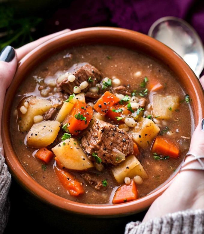 Holding a bowl of beef barley soup