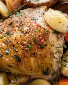 One Pan Roasted Chicken and 40 Cloves of Garlic | Chicken thighs are roasted with garlic, herbs, white wine, potatoes and carrots for an incredibly flavorful one pan meal! | The Chunky Chef | #dinnerrecipe #chicken #roasted #onepan #onepot #easyrecipe