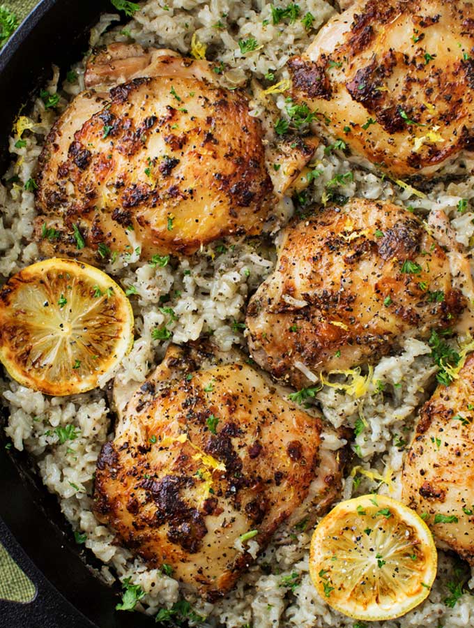 Marinated Greek lemon chicken thighs are seared then baked on top of a lemon and herb flavored rice.  The easiest one pan meal that the whole family will love! 