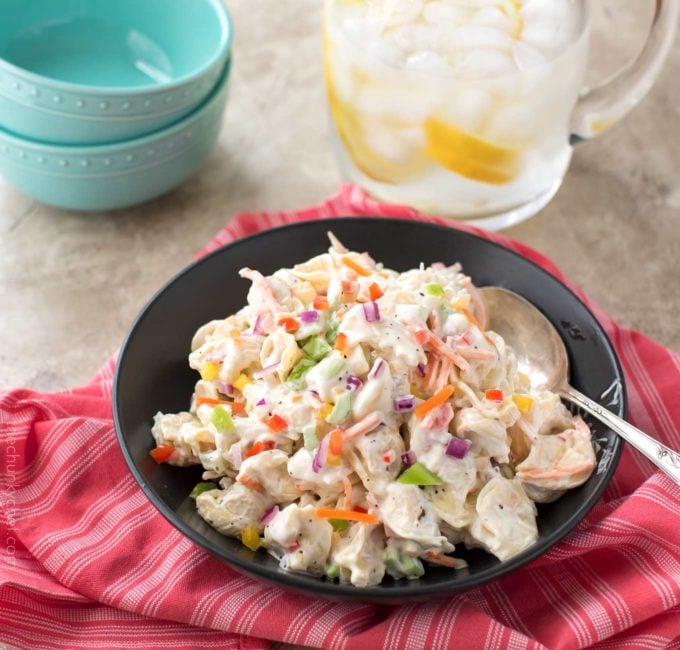 Bowl full of creamy pasta salad with serving spoon