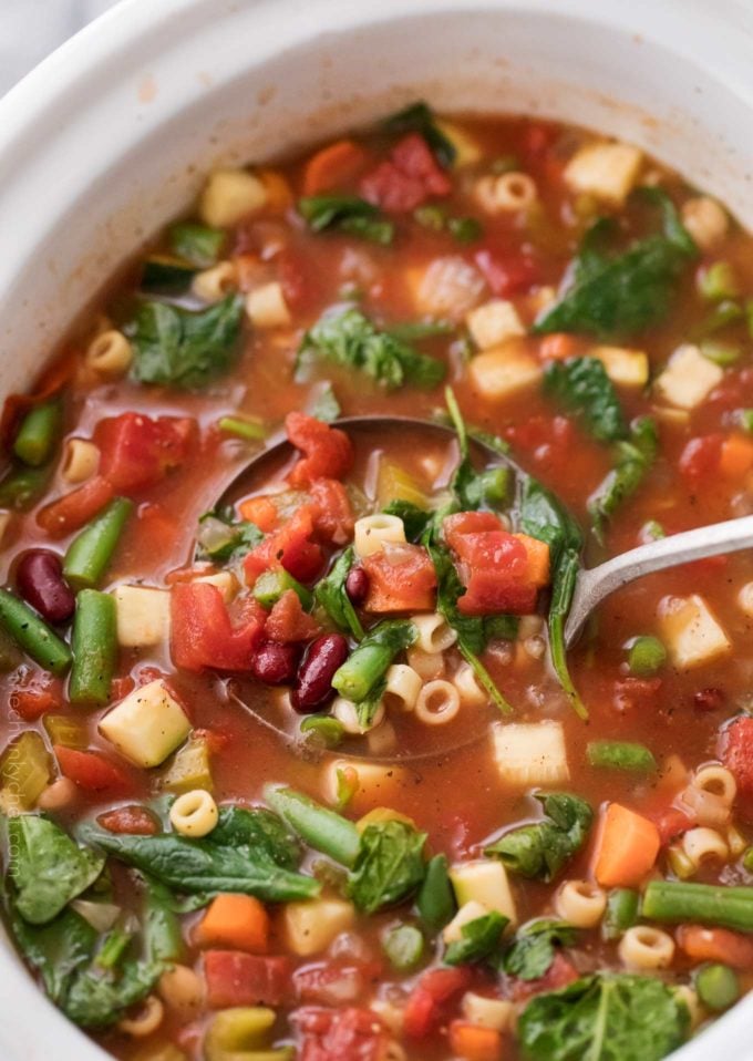 Ladle of minestrone soup in crockpot