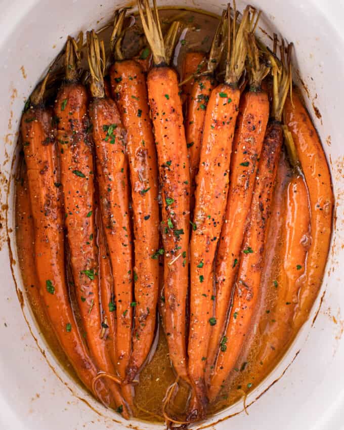 Tender baby carrots are coated in a sweet and savory glaze, then "roasted" in the crockpot! Free up your oven with this EASY side dish that's perfect for the holidays! | #carrots #sidedish #holidaysidedish #holidayrecipe #slowcookercarrots #crockpotcarrots glazed carrots inside slow cooker