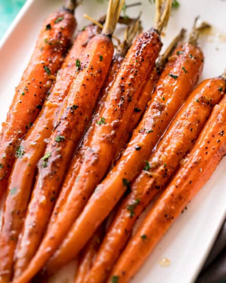 Tender whole baby carrots are coated in a sweet and savory glaze, then "roasted" in the slow cooker!  Free up your oven with this EASY side dish that's perfect for the holidays! #carrots #sidedish #holidayrecipe