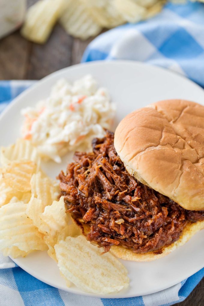 Beef barbecue on bun with coleslaw and potato chips