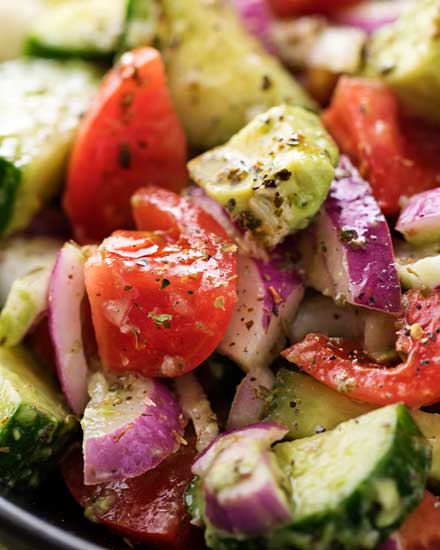 This summery tomato avocado salad is full of buttery avocados, juicy tomatoes and crisp red onions, and tossed in a mouthwatering homemade Greek-inspired dressing! | #avocado #greek #salad #avocadosalad #tomatosalad #potluck
