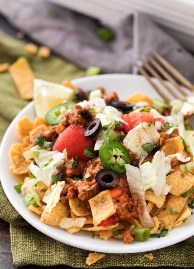 Scoop of taco casserole served over Fritos chips on white plate