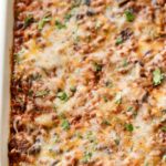 This beef and bean taco casserole is incredibly easy, made from scratch, freezer-friendly, and a huge hit families!  All the flavors of taco night that you love, in a comforting casserole to feed a crowd. #taco #tacocasserole #mexican #freezermeal #casserole #makeahead #tacotuesday