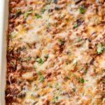 This beef and bean taco casserole is incredibly easy, made from scratch, freezer-friendly, and a huge hit families!  All the flavors of taco night that you love, in a comforting casserole to feed a crowd. #taco #tacocasserole #mexican #freezermeal #casserole #makeahead #tacotuesday