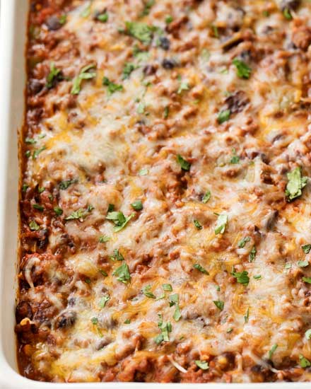 This beef and bean taco casserole is incredibly easy, made from scratch, freezer-friendly, and a huge hit families!  All the flavors of taco night that you love, in a comforting casserole to feed a crowd. #taco #tacocasserole #mexican #freezermeal #casserole #makeahead #tacotuesday