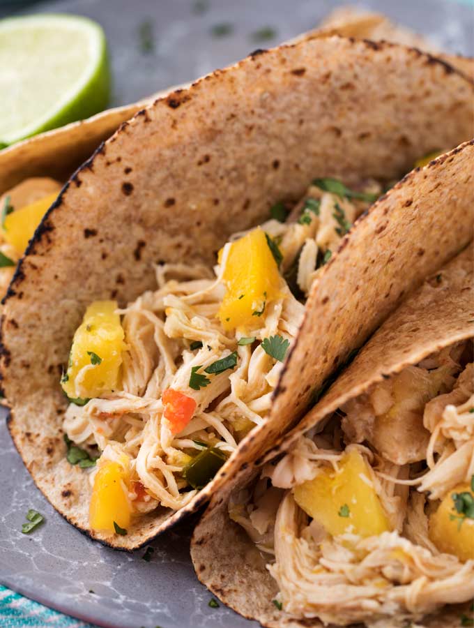 Tender, juicy, sweet and spicy crockpot chicken tacos, perfect for taco night!  Just 1 freestyle smart point per serving means you can have tacos without the guilt! | #chickentacos #tacotuesday #crockpot #slowcooker #weightwatchers