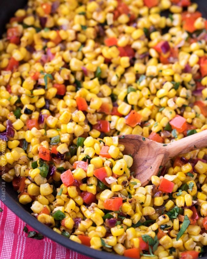 Southwest corn salad in skillet with wooden spoon