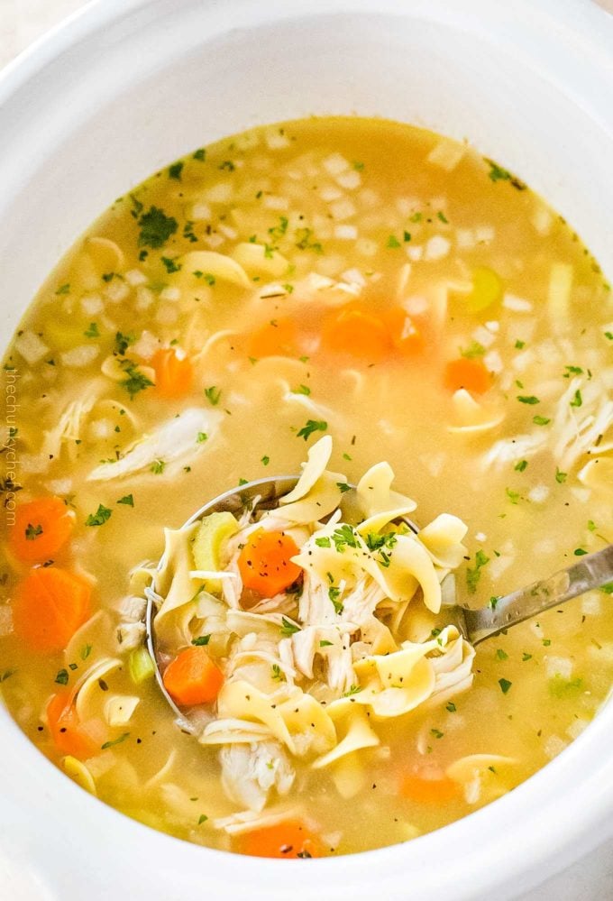 Ladle of chicken noodle soup in crockpot