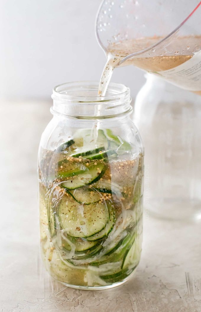 Pouring pickling brine in container for freezer pickles