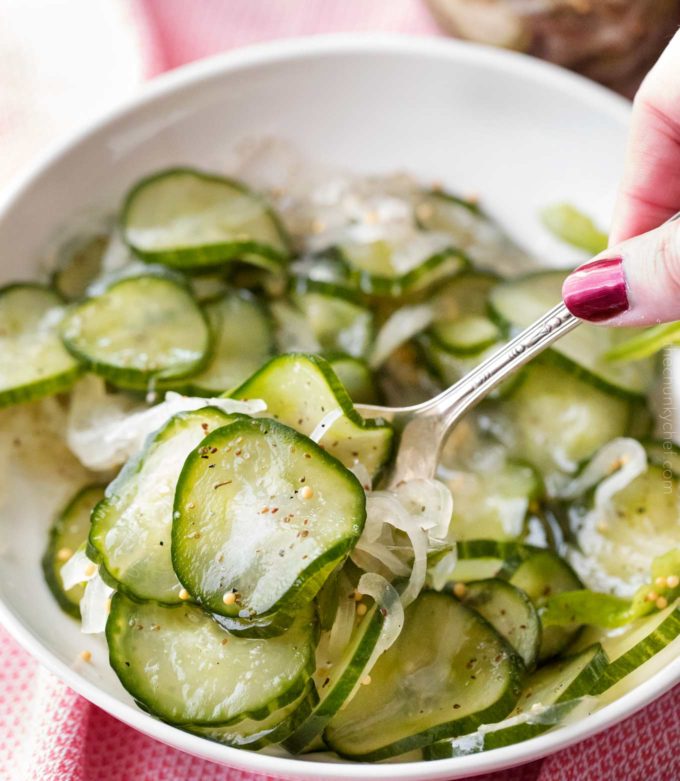 Spoonful of sweet pickles in white bowl