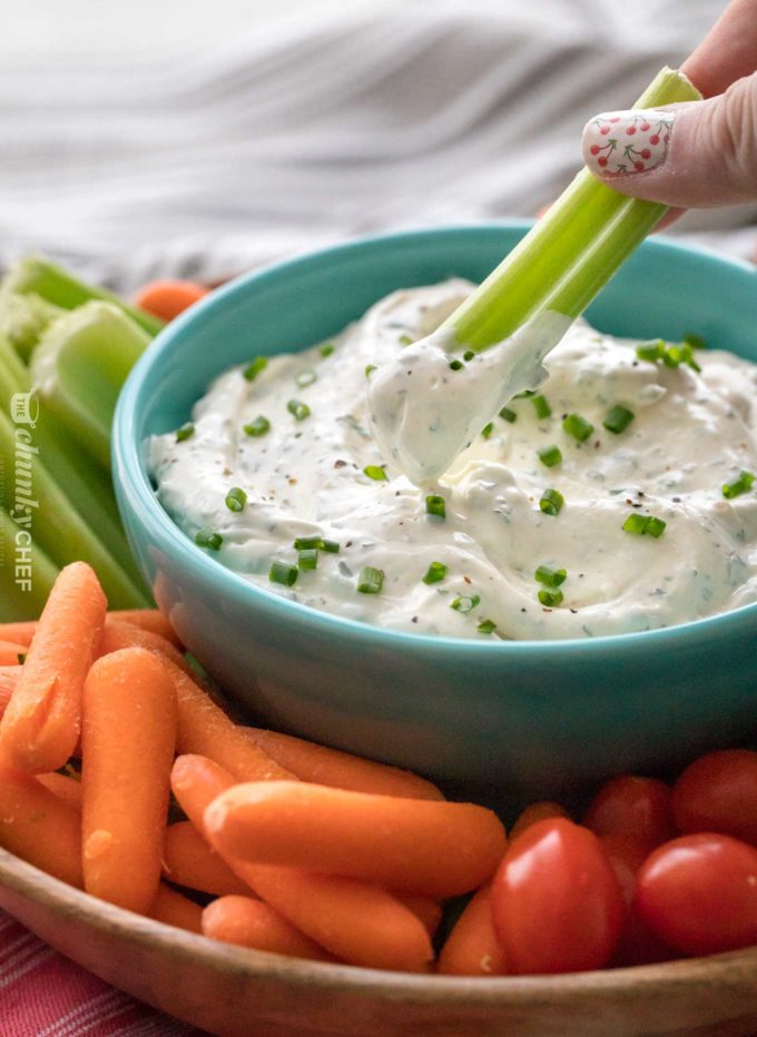 Scoopful of veggie dip on celery stick