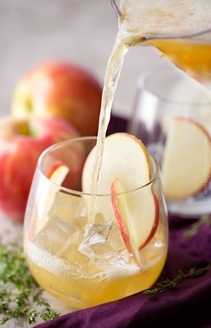 Pouring maple honeycrisp bourbon cocktail into glass