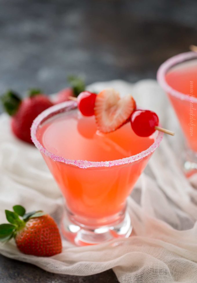 Pink vodka cocktail with strawberry and cherry garnish