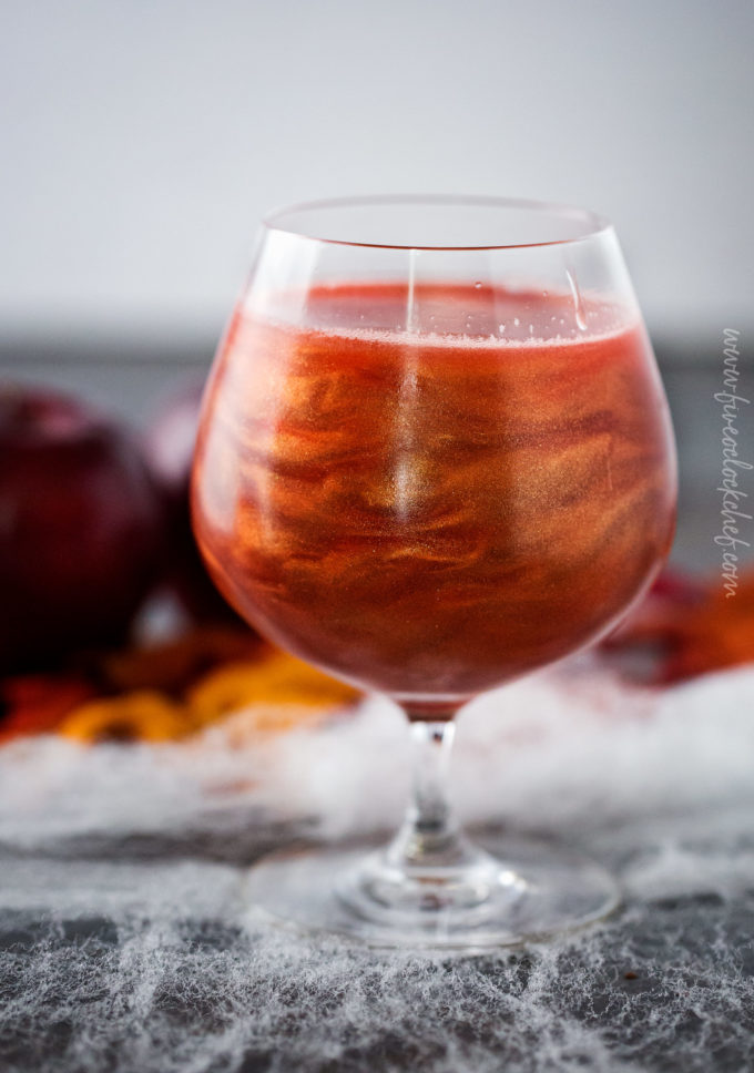 Swirls of luster dust in poisoned apple cider cocktail