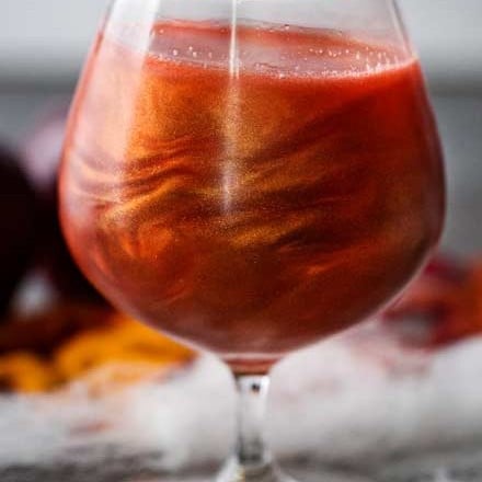 Perfect for Fall and Halloween, this sweet and eerily beautiful cocktail is made with just a handful of ingredients, and tastes every bit as great as it looks! #cocktail #drink #applecider #Halloween #Fall #falldrink #drinks #lusterdust #viniq 